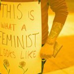 A person stands holding a plackard, declaring their pro-feminism ideology.