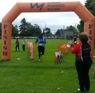 Participant crossing the finish line at the Tri of Compassion