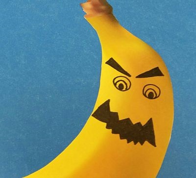 Cropped image of part of a nightmare banana with mean face drawn on. Mouth is dark and jagged, eyes open and glaring